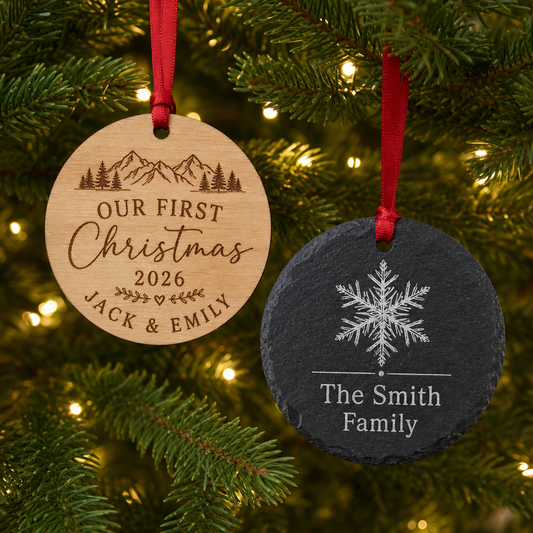 Personalized engraved Christmas ornaments in natural wood and slate hanging on a lit Christmas tree